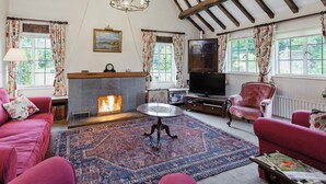 A cozy living room with a fireplace, a television, and comfortable seating. - 3 bedroom accommodation in Bucknell, near Clun (Bucknell, near Clun)