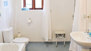 A bathroom with a toilet, a small step stool, a shower, and a sink. - 2 bedroom accommodation in East Tytherton, Chippenham (East Tytherton, Chippenham)
