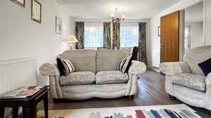 A living room with a sofa, armchairs, a coffee table, and a patterned rug. - 2 bedroom accommodation in Fressingfield (Fressingfield)