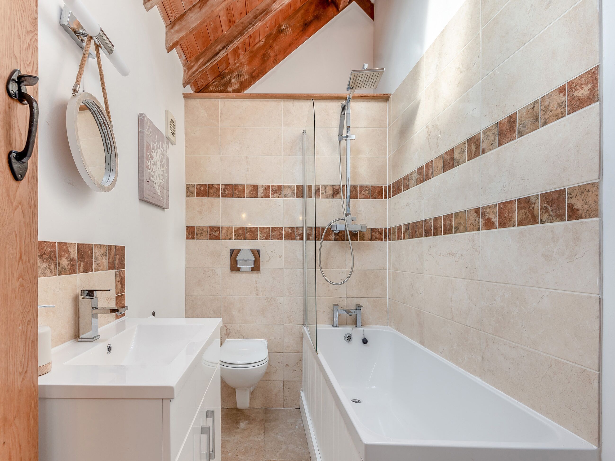 Een badkamer met een bad, toilet en douche.
