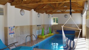A pool area with a hammock, lounge chairs, and a pool depth sign. - 3 bedroom accommodation in Waterrow, near Wiveliscombe (Waterrow, near Wiveliscombe)