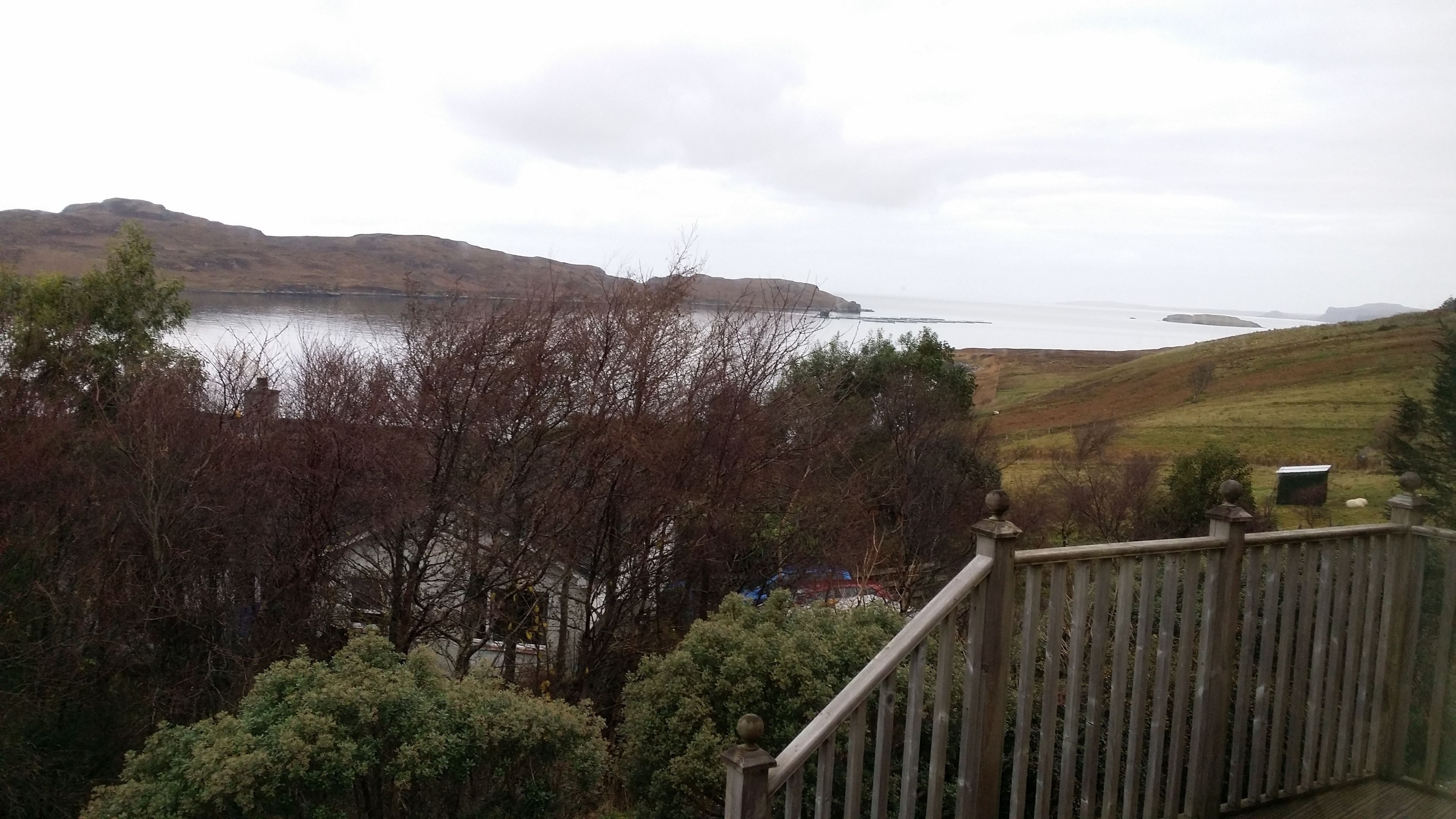 A view from a balcony overlooking a body of water with hills in the background.