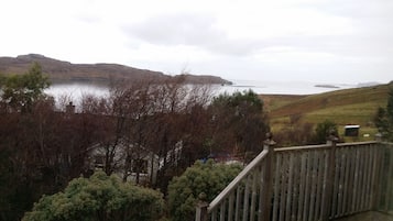 A view from a balcony overlooking a body of water with hills in the background.