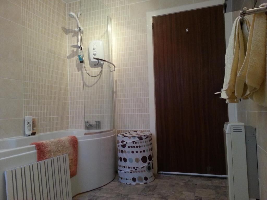 A bathroom with a bathtub, a shower, a toilet, and a towel rack.