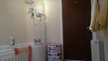 A bathroom with a bathtub, a shower, a toilet, and a towel rack.