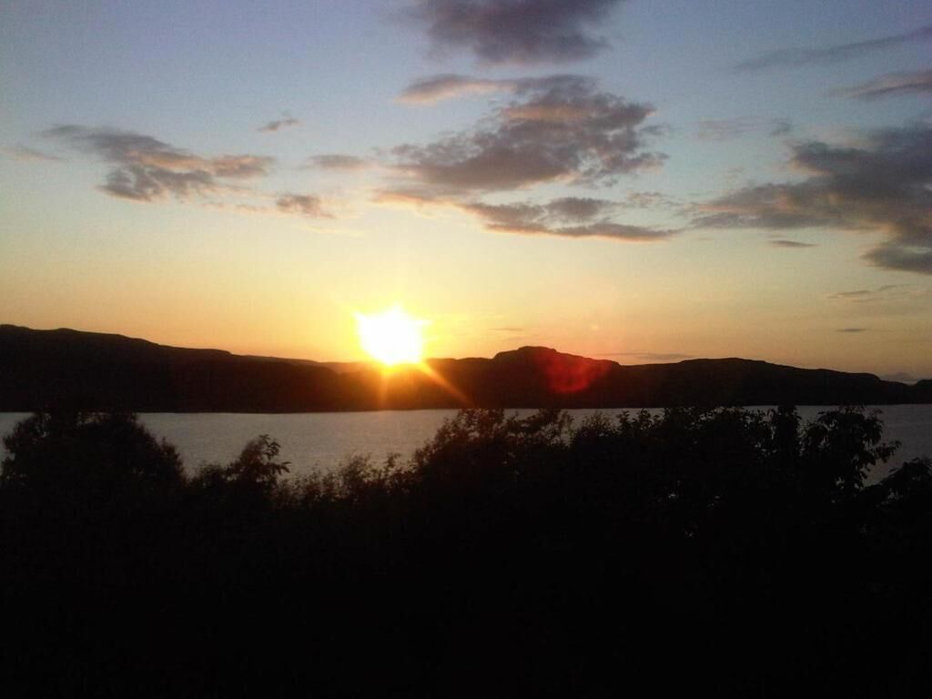 A sunset over a body of water with mountains in the background.