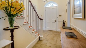 A staircase with white railings and a vase of yellow flowers on a table. - 6 bedroom accommodation in Fring, near Kings Lynn (Fring, near Kings Lynn)