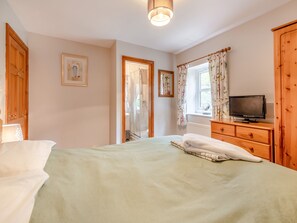 A bedroom with a bed, a television, a wooden wardrobe, and a window with curtains. - 3 bedroom accommodation in York (York)