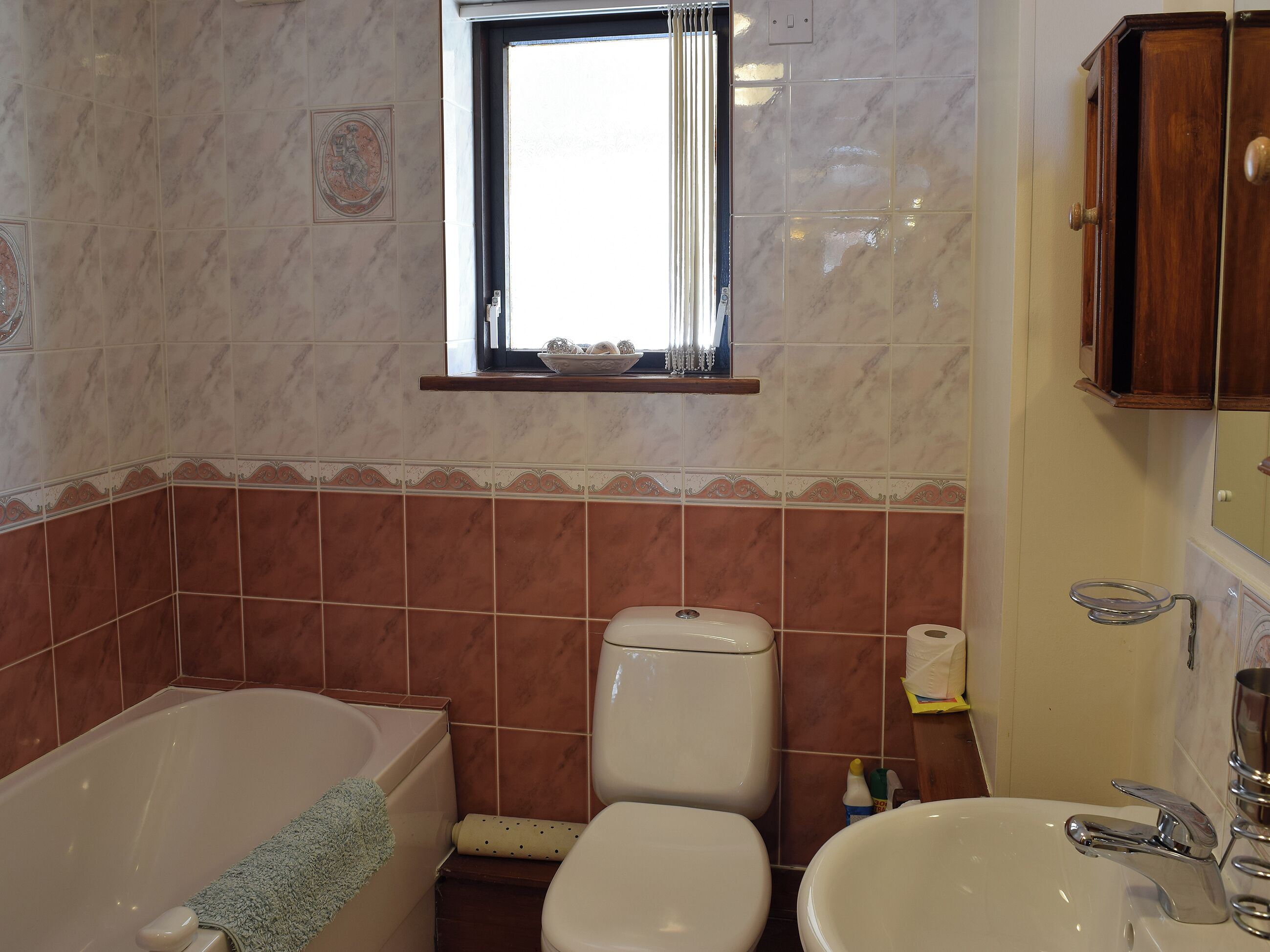A bathroom with a bathtub, toilet, and sink.
