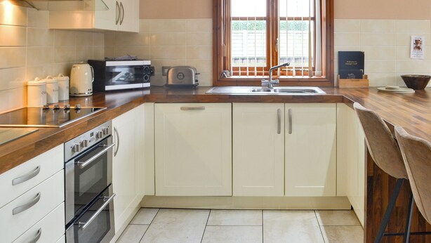 A kitchen with a stove, oven, toaster, and a window with blinds. - George's Gaff - E4432 (Near Skegness)