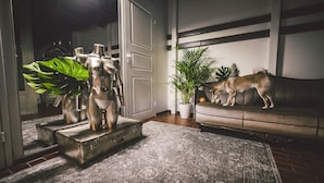 A living room with a sofa, a plant, and a sculpture. - Wherever Boutique Hostel (Rovaniemi)