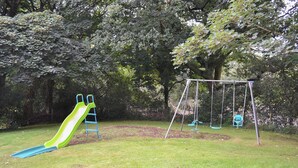 A playground with a slide and swings. - 2 bedroom accommodation in St Austell (St Austell)