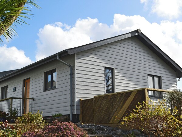 A house with a gabled roof, a front porch, and a wooden fence.