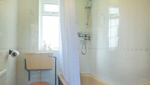 Une salle de bain équipée de toilettes, d’une baignoire et d’une douche.