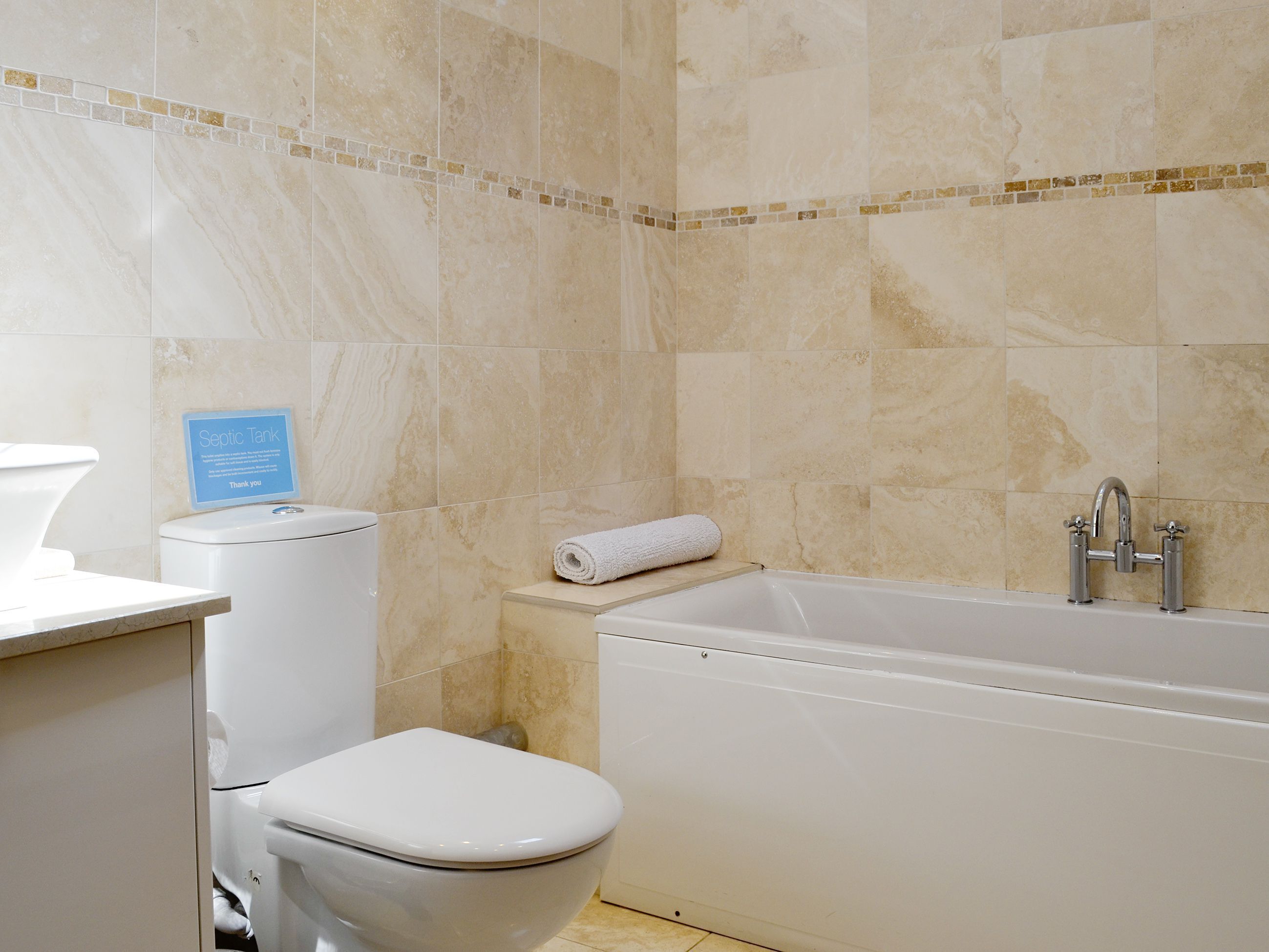 Un baño con inodoro, lavamanos y bañera.