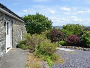 A stone building with a white door and a stone pathway leading to it.