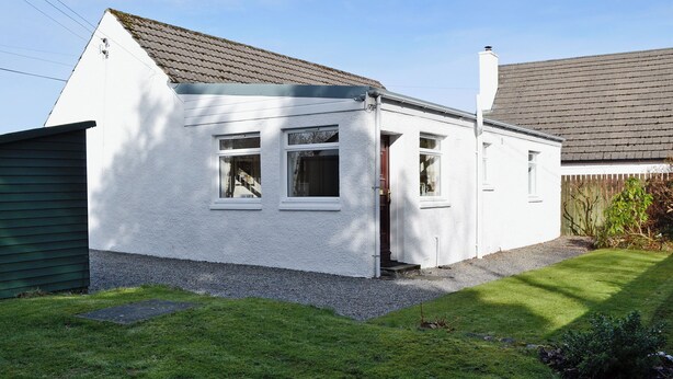 A single-story white house with a sloped roof, a front door, and two windows. - 2 bedroom accommodation in Benderloch near Oban (Benderloch near Oban)