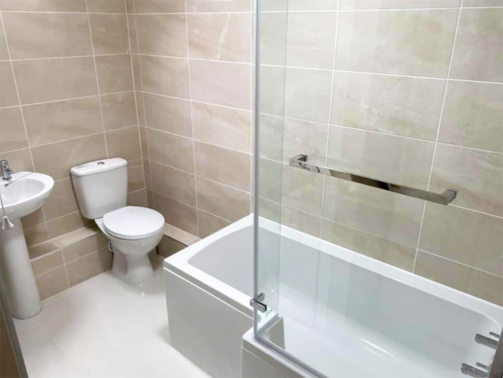 Een badkamer met toilet, wastafel en douchecabine.