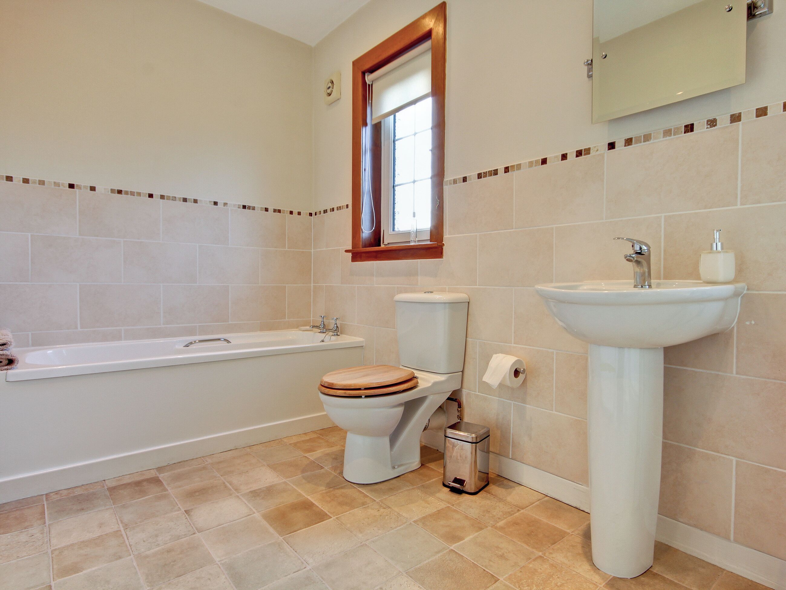 A bathroom with a bathtub, toilet, and sink.