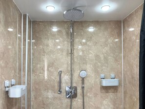 A modern bathroom with a shower, two sinks, and a mirror.
