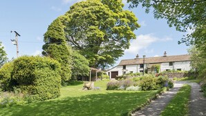 A traditional stone house with a garden pathway leading to the entrance.