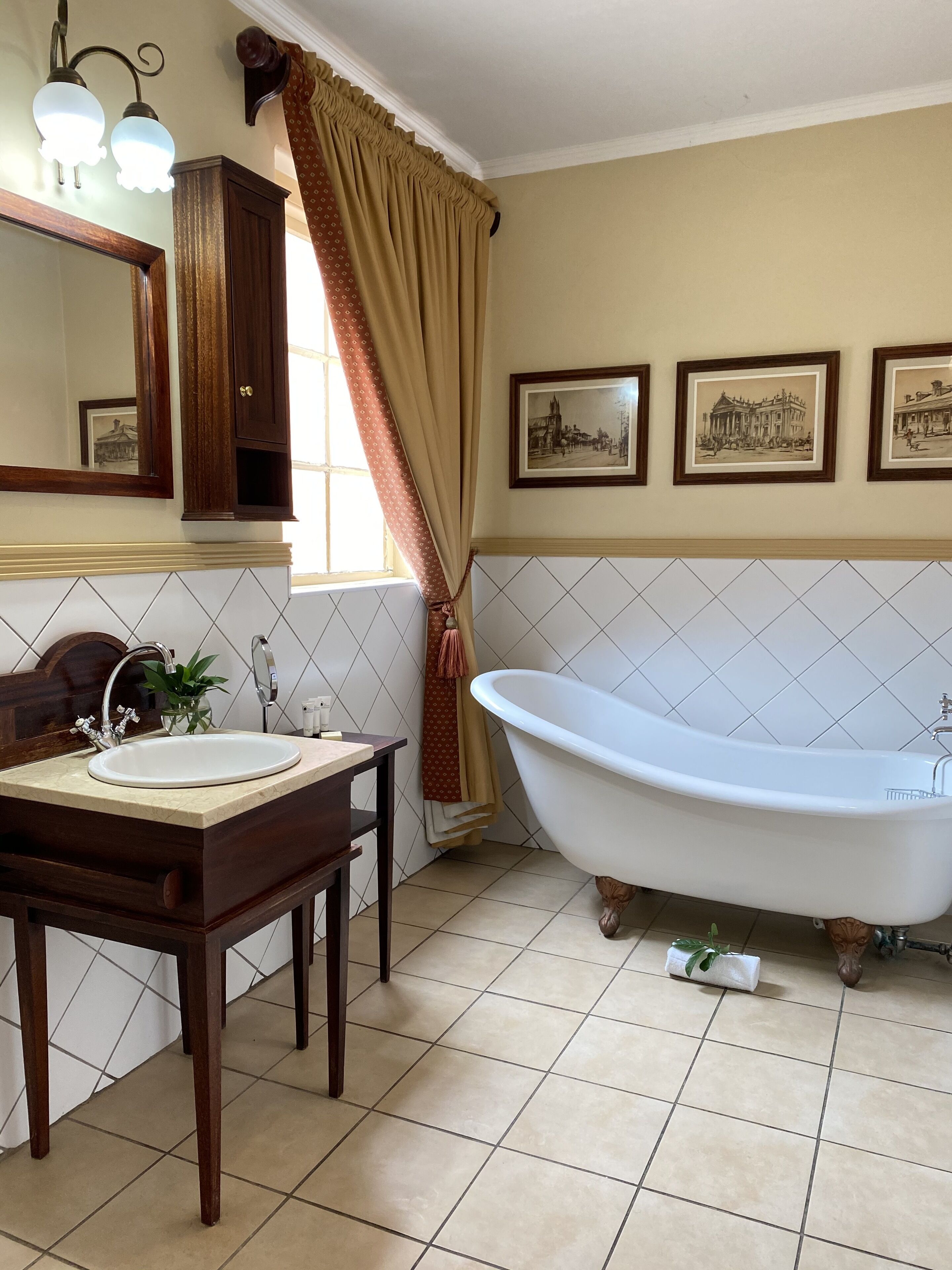 Un bagno con una vasca freestanding, un lavabo con specchio e un armadietto.