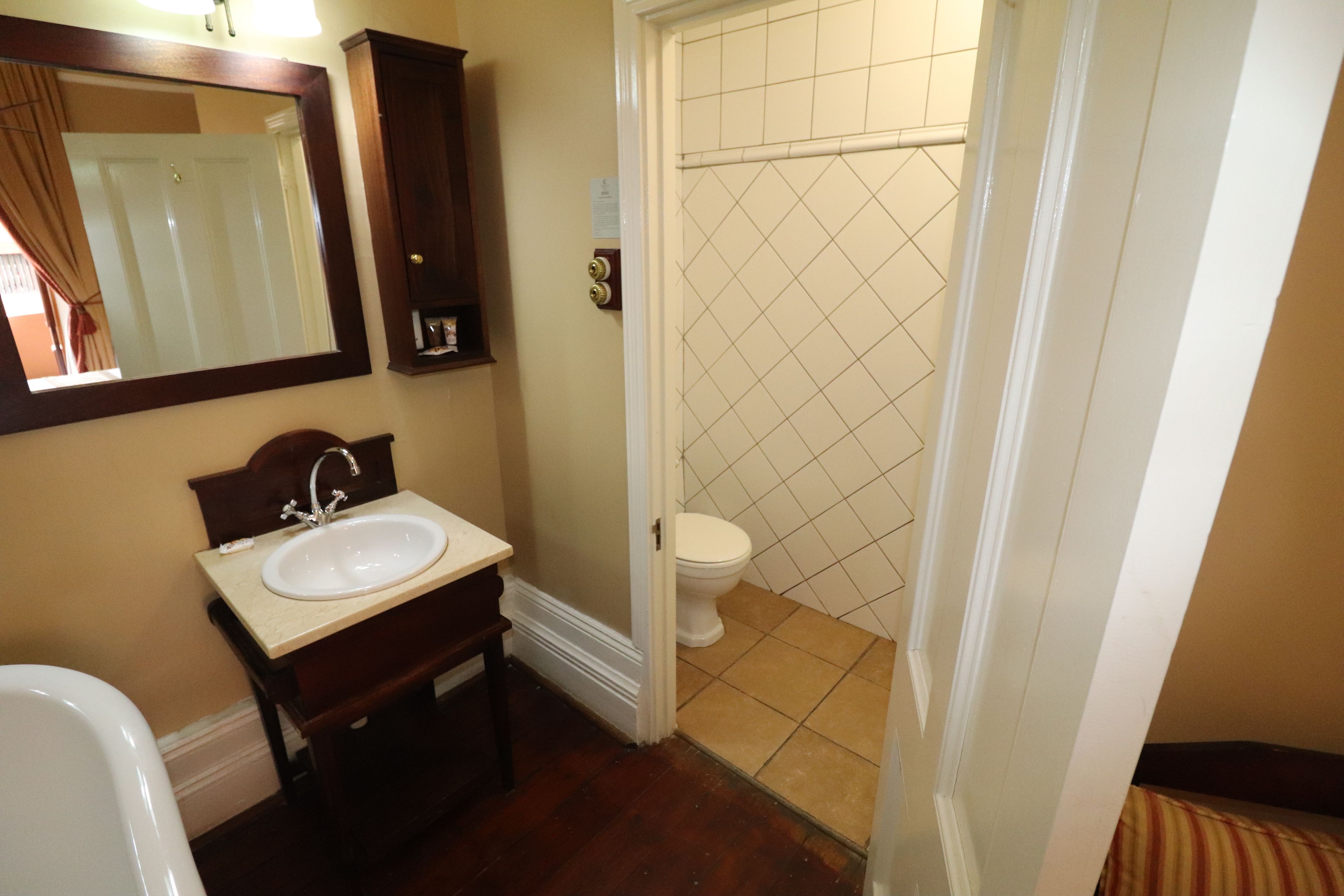 Un baño con lavamanos, espejo e inodoro.