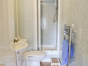 A bathroom with a white sink, toilet, and shower.