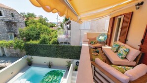 Un balcon avec piscine, un espace salon extérieur et une vue sur les environs.