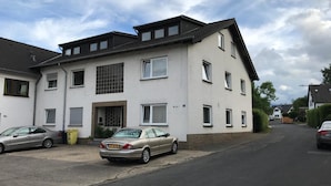 A two-story residential building with a flat roof, multiple windows, and a garage door. - Gästehaus Fries (Blankenheim)
