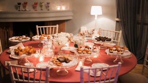 A round table set for a meal with various dishes, white flowers, and candles. - Assteas Bed & Breakfast (Montesarchio)