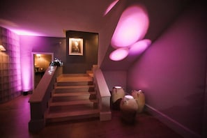 Un escalier au design moderne, menant à une œuvre d’art encadrée accrochée au mur.