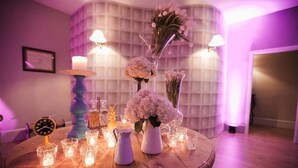 A round wooden table with a clock, candles, and floral arrangements. - Assteas Bed & Breakfast (Montesarchio)