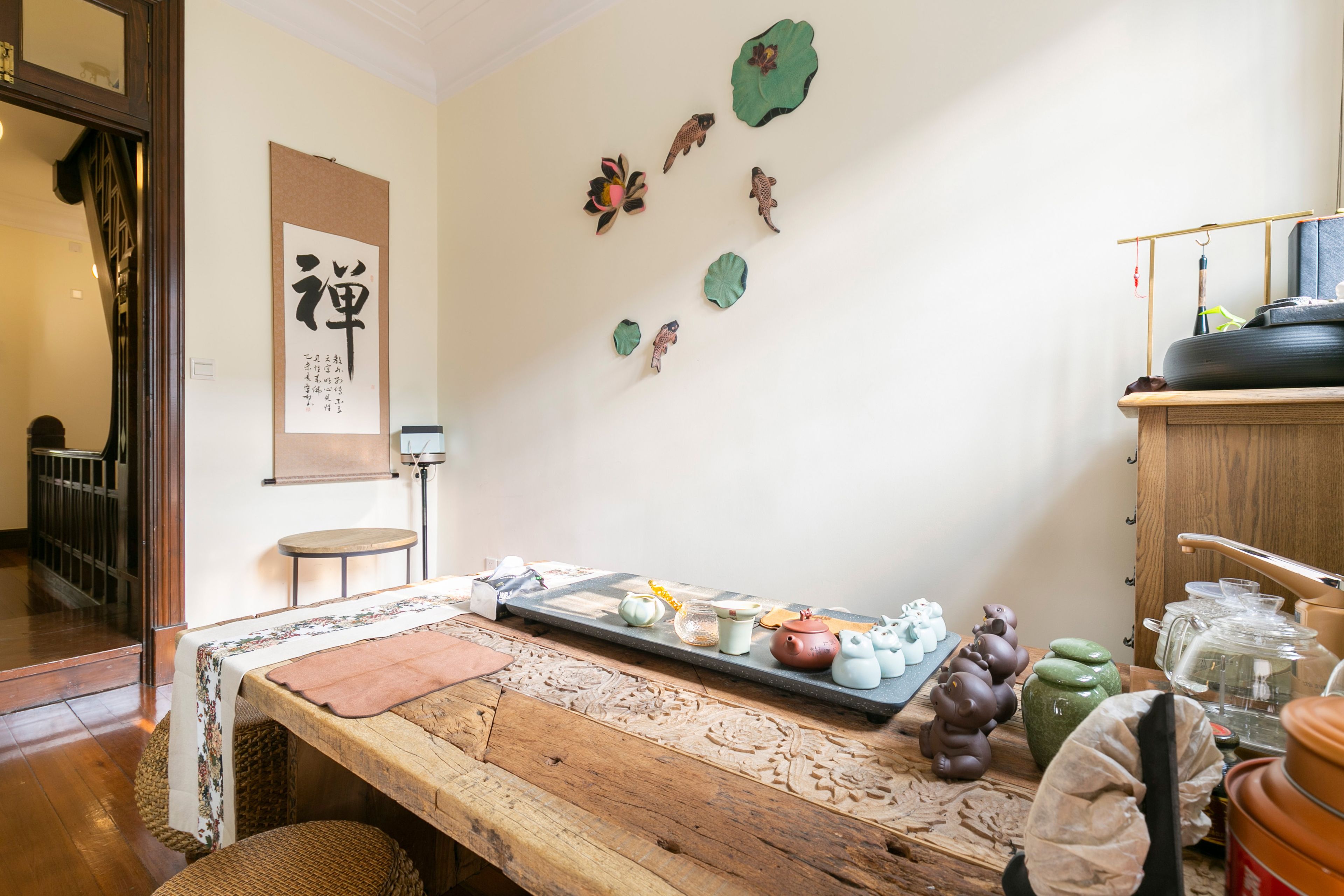 A traditional Japanese room with tatami flooring, a low wooden table, and various decorative items including ceramics and wall art.