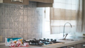 Eine Küche mit Gasherd, Kaffeemaschine und einer Packung Follet-Kaffee.