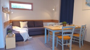 Ein gemütlicher Wohnbereich mit einer Couch, einem kleinen Tisch und Sesseln.