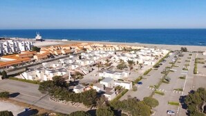Ein Küstenwohngebiet mit einer Marina, weißen Gebäuden und freiem Blick auf das Meer.