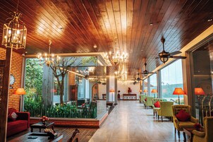 A spacious lobby with wooden ceiling, large windows, and multiple seating areas.