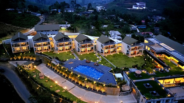 A modern hotel with multiple buildings, a central swimming pool, and well-lit pathways. - The Argyle (Hatton)