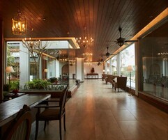 Un comedor espacioso y moderno con suelo de madera, ventanas amplias y elegantes lámparas de araña.