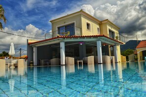 A two-story building with a balcony overlooking a swimming pool. - SunRose Beach Aparthotel (Corfu)