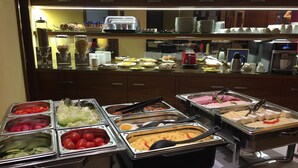 Un buffet con diverse opzioni tra cui frutta, verdura, carni e latticini.
