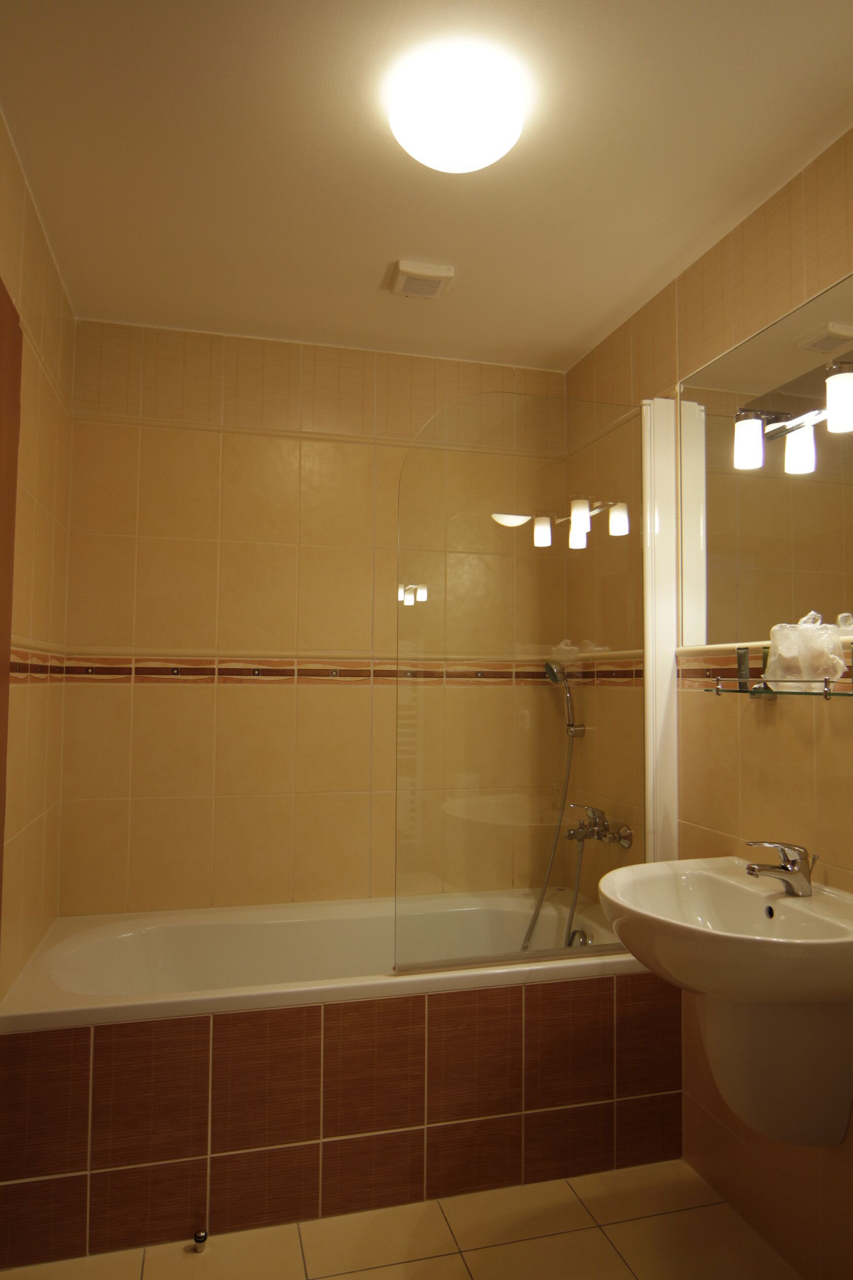 A bathroom with a bathtub, a sink, and a mirror.