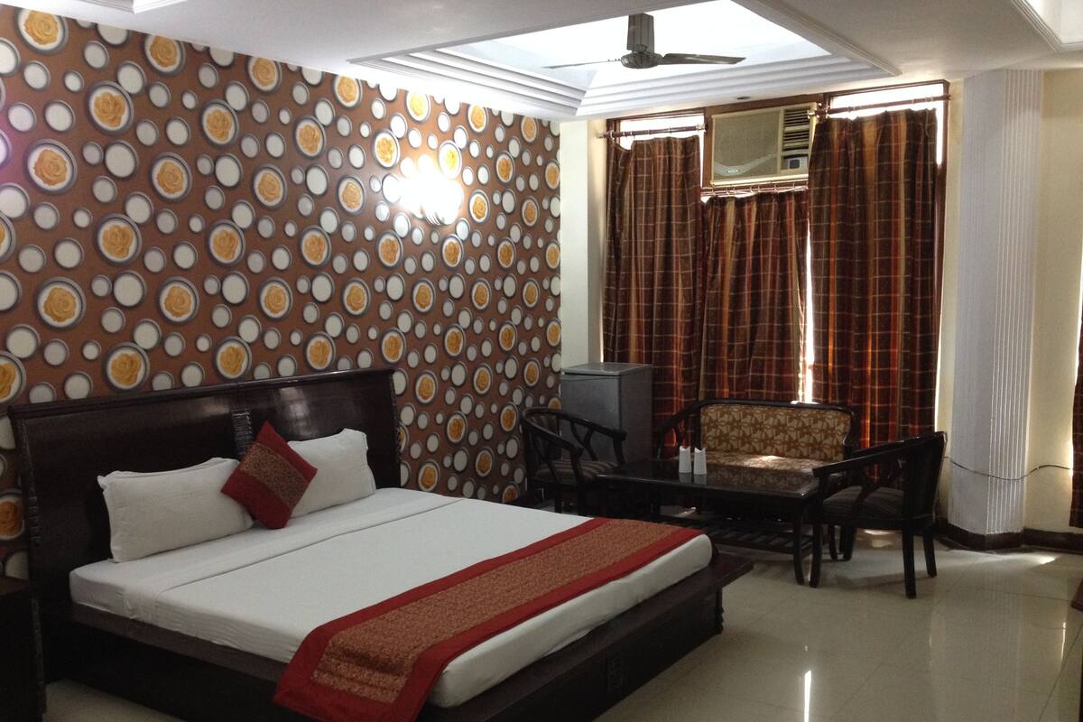 Habitación de hotel con cama, escritorio, silla y pared con diseño.
