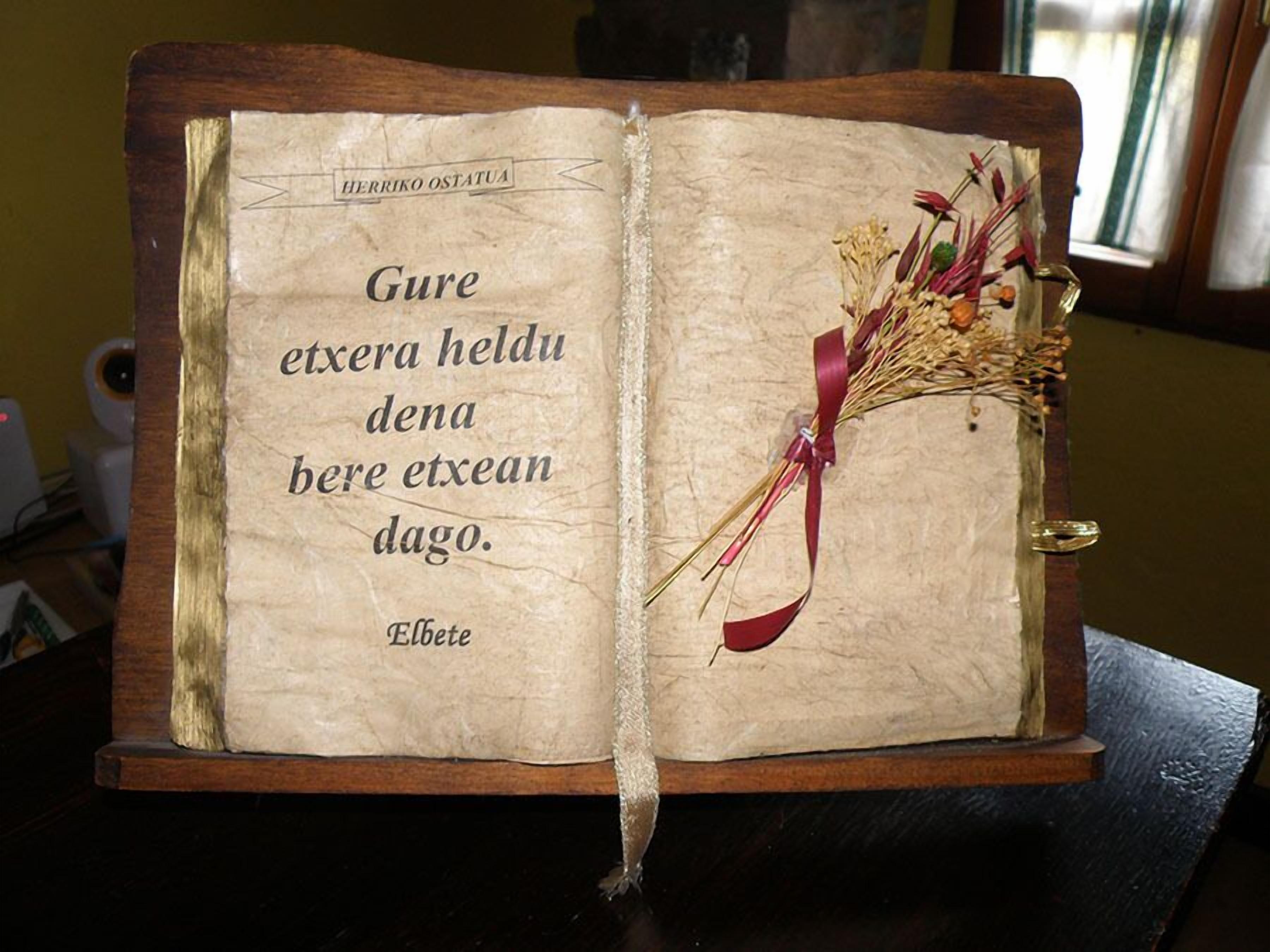 Un libro abierto con una cita en la página izquierda y un ramo de flores secas en la derecha.
