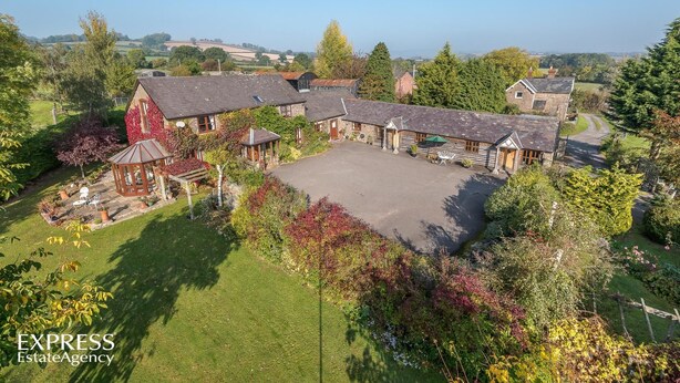 A large estate with multiple buildings, a spacious courtyard, and surrounding greenery. - Highgrove Barns (Craven Arms)