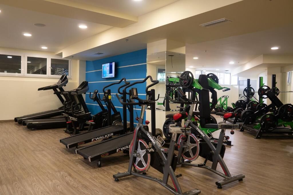 Una palestra con tapis roulant, ellittiche e macchinari per pesi.
