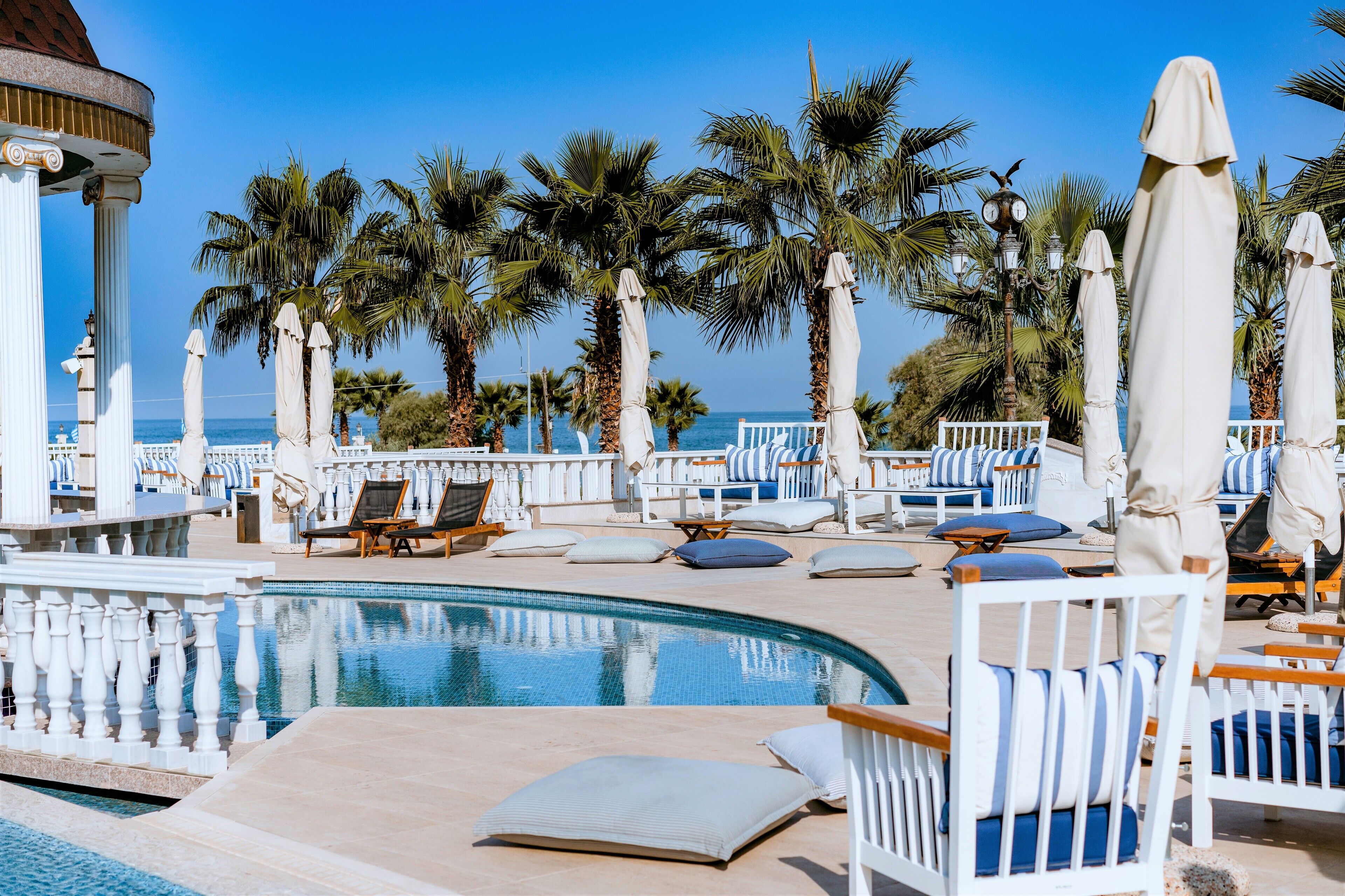 Una piscina al aire libre de temporada, sombrillas, tumbonas