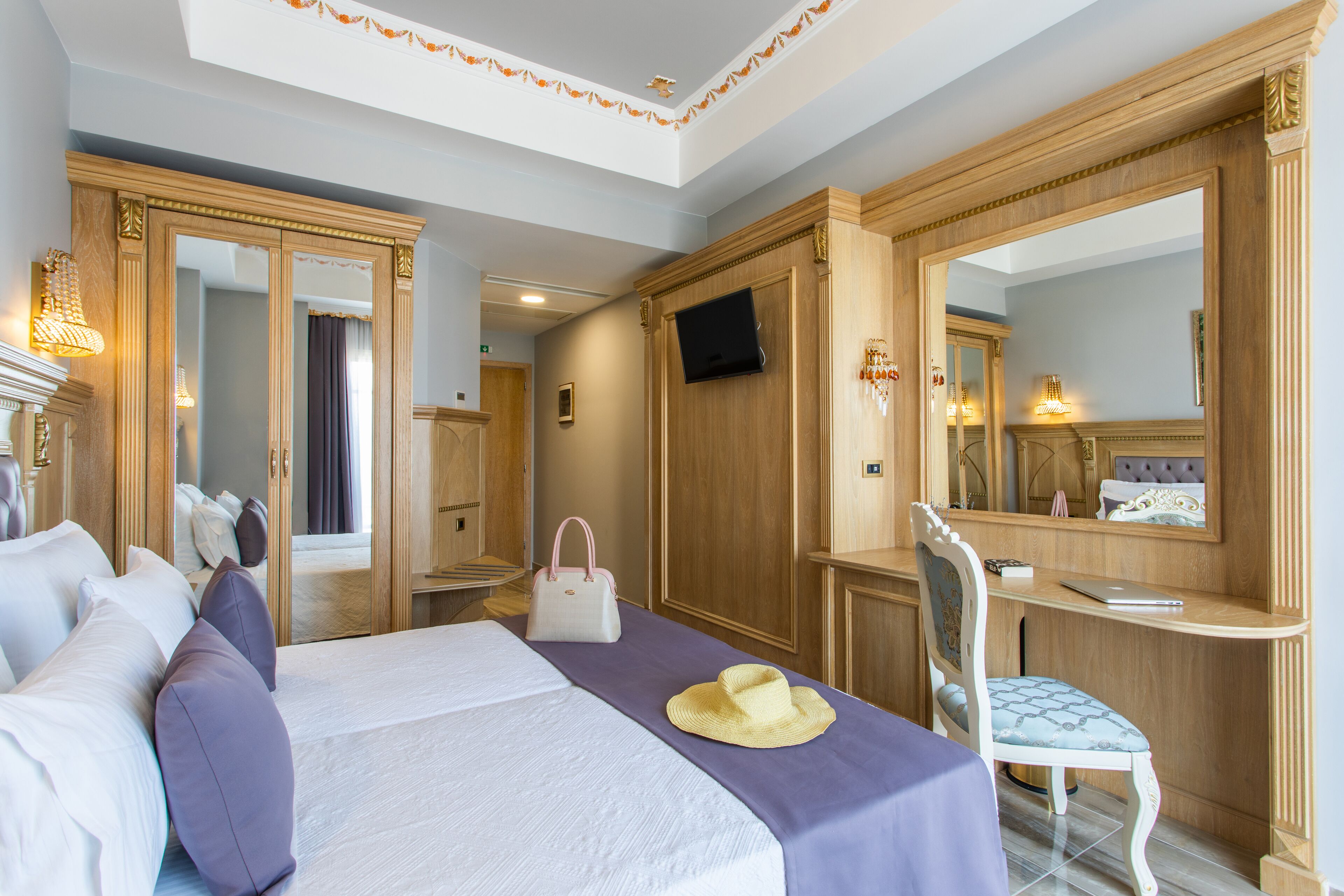 Una habitación de hotel con una cama grande, un escritorio, una silla y un televisor.