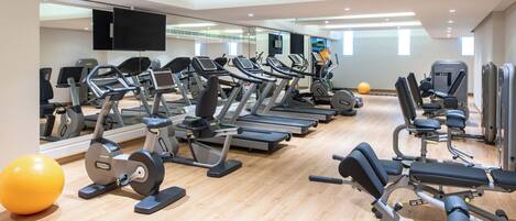 A gym with treadmills, elliptical machines, and weight equipment.